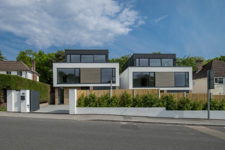 Front streetview of zinc clad, white rendered, glass frontage contemporary houses designed 